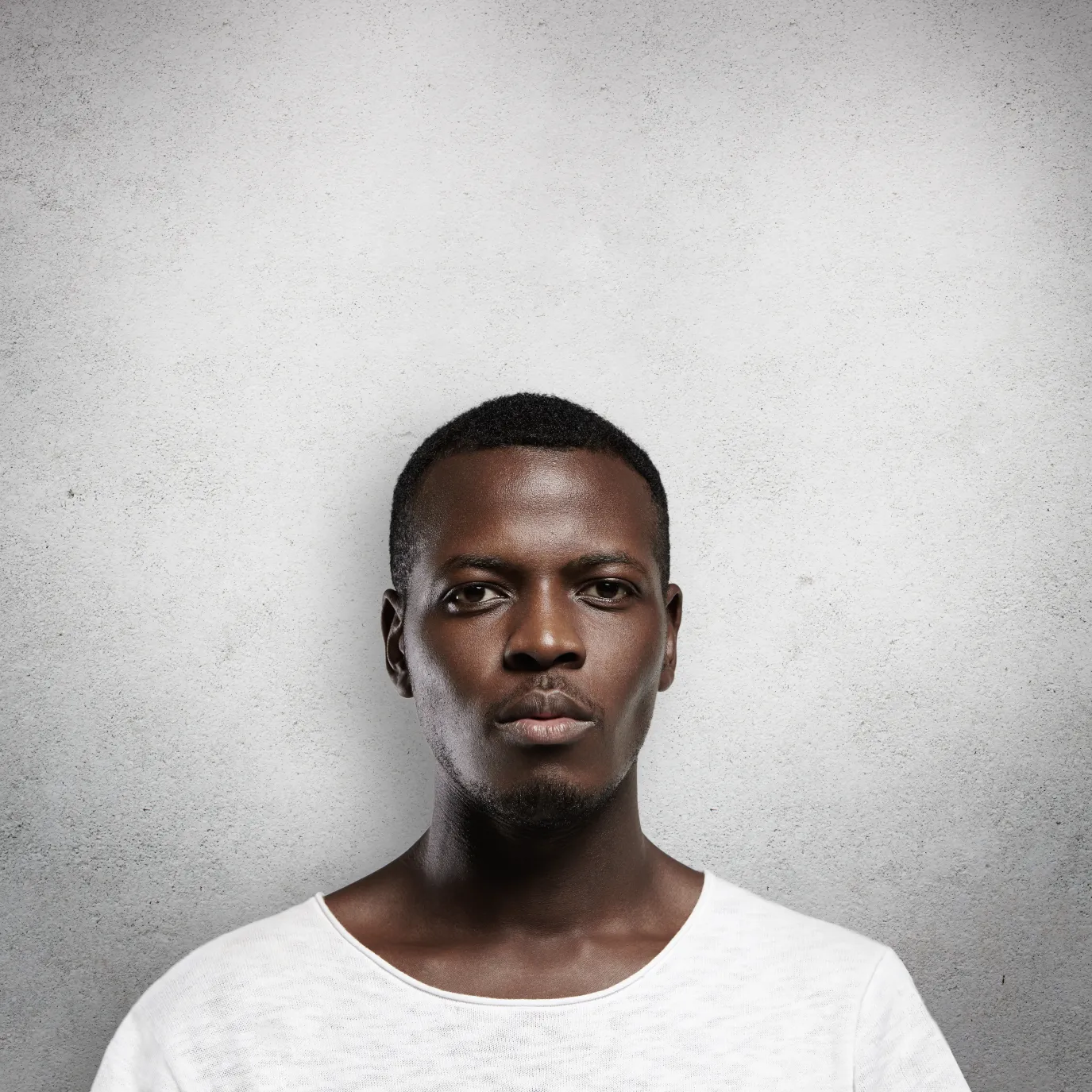 headshot-serious-confident-young-dark-skinned-male-standing-isolated-against-gray-wall